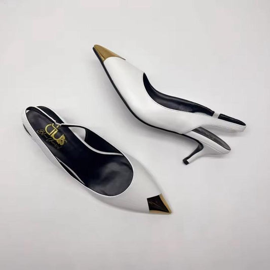 Black high-heeled shoes with gold accents on a light gray background